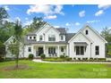 White farmhouse exterior boasts a charming front porch and manicured lawn at 5811 Kristi Ln, Midland, NC 28107