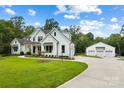 White farmhouse with attached three-car garage and spacious driveway at 5811 Kristi Ln, Midland, NC 28107