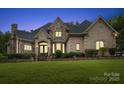 Elegant brick home with a manicured lawn at dusk at 8516 Mcilwaine Rd, Huntersville, NC 28078