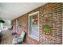 Covered brick front porch with chair, green lantern, and white ceiling at 9143 Sadlers Ridge Rd, Fort Mill, SC 29707