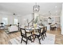 Open-concept space features a glass dining table, seamlessly blending dining and living areas, with a view into the kitchen at 3230 Rogers St, Charlotte, NC 28208