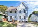 Inviting two-story home showcasing bright siding, manicured lawn, and a welcoming entrance, all under a clear sky at 3230 Rogers St, Charlotte, NC 28208