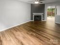 Bright living room showcasing a fireplace, ceiling fan, and wood-look flooring at 6003 Heath Valley Rd, Charlotte, NC 28210