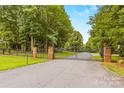 A long driveway leads to a gated entrance, surrounded by lush greenery at 127 Tradition Ln, Mooresville, NC 28115