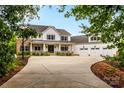 Charming two-story home with a spacious front porch, three-car garage and a wide driveway at 127 Tradition Ln, Mooresville, NC 28115