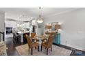Elegant dining area features a glass table set, stylish lighting, and is adjacent to a modern kitchen at 12119 Brooklyn Ave, Charlotte, NC 28204