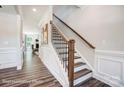 Wooden staircase with black metal balusters and dark hardwood floors at 8611 Frank Grier Rd # 1, Charlotte, NC 28215