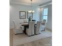 Bright dining room features neutral decor, modern lighting, a decorative table setting, and beautiful wood floors at 5225 Glenwalk Dr # 0061, Charlotte, NC 28269