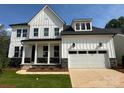 New two story home boasts white siding, a black roof, a two car garage, and a charming front porch at 5225 Glenwalk Dr # 0061, Charlotte, NC 28269