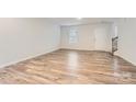 Bright living room features wood-look flooring and leads to an interior staircase at 1608 Cannonball Ln, Bessemer City, NC 28016