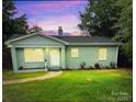 Charming light blue house with a landscaped yard at dusk at 647 Reeves Ct, Charlotte, NC 28208