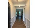 A spacious hallway with elegant wainscoting that leads to the living area at 8165 Annsborough Nw Dr, Concord, NC 28027
