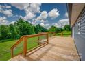 View of the backyard from the wooden deck with metal wire railing at 55 Shannon Park Cir, Taylorsville, NC 28681