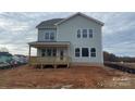 A beautiful back exterior showcasing a wooden deck, light green siding, and picturesque view of the neighborhood at 4808 Glen Stripe Dr # Cal0036, Indian Trail, NC 28079