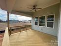 This back porch has a wooden railing, ceiling fan, and views of the surrounding neighborhood at 4808 Glen Stripe Dr # Cal0036, Indian Trail, NC 28079