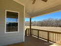 Covered porch with wood decking, railing, and a view of the undeveloped backyard at 4808 Glen Stripe Dr # Cal0036, Indian Trail, NC 28079