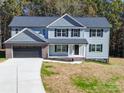 Two-story house with blue siding, black garage doors, and a landscaped yard at 1133 Heather Oak Ln, Oakboro, NC 28129