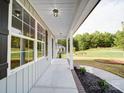 Covered porch with view of lush yard and neighboring home at 1133 Heather Oak Ln, Oakboro, NC 28129