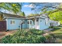 Charming home showcasing light blue siding, green landscaping, and inviting pathway to the front door at 209 21St St, Newton, NC 28658