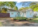 Charming single-story home featuring light blue siding, well-manicured landscaping, and welcoming front entrance at 209 21St St, Newton, NC 28658