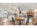 Cozy dining area with a fireplace, hardwood floors, and a view into the kitchen at 1007 Ashford St, Charlotte, NC 28214