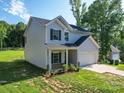 Two-story home featuring an attached garage, well-kept lawn, and mature trees at 8932 Myra Way, Charlotte, NC 28215