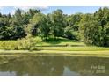 Peaceful waterfront property with lush green landscaping at 721 Orphanage Rd, Concord, NC 28027