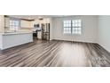 Modern kitchen with stainless steel appliances and gray wood-look floors at 1610 Cannonball Ln, Bessemer City, NC 28016