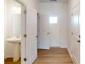 Bright bathroom featuring a pedestal sink and a classic white door at 4061 Lawnview Dr, Charlotte, NC 28269