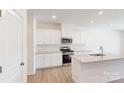 Modern kitchen with white cabinets, granite countertops, and stainless steel appliances at 4061 Lawnview Dr, Charlotte, NC 28269
