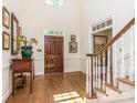 Spacious entryway with hardwood floors, staircase, and decorative artwork at 4301 Fairview Oaks Dr, Charlotte, NC 28211