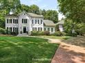 Gray brick home with lush landscaping and a brick driveway at 4301 Fairview Oaks Dr, Charlotte, NC 28211