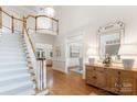 Elegant foyer with a grand staircase, light hardwood floors, and stylish decor at 4301 Fairview Oaks Dr, Charlotte, NC 28211