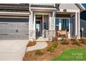 Inviting front porch with stone details and a welcoming bench at 1314 Idyllic Ln, Waxhaw, NC 28173