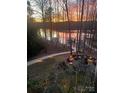 Enjoy sunsets over the lake from the stone firepit with built-in seating at 167 Maple View Dr, Troutman, NC 28166