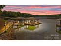 Scenic sunset view of lakefront property with multiple boat docks at 167 Maple View Dr, Troutman, NC 28166