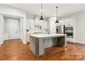 Modern kitchen featuring a center island, stainless steel appliances, and stylish pendant lighting at 16004 Deer River Rd, Charlotte, NC 28278