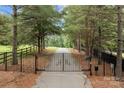 Ornate iron gates open to a private driveway at 4364 Hager Mountain Ln, Iron Station, NC 28080