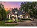 Charming home with stone and brick exterior, manicured landscaping, and inviting entrance at dusk at 4364 Hager Mountain Ln, Iron Station, NC 28080