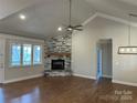 Cozy living room with a stone fireplace, hardwood floors, a ceiling fan, and large windows at 5106 Silver Trace Ln # 90, Denver, NC 28037