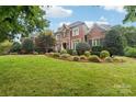 Brick home with manicured lawn and landscaping at 7025 Willow Trace Ln, Weddington, NC 28104