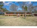 Charming brick ranch home with mature landscaping and a walkway to the front door at 1206 Mineral Springs Rd, Charlotte, NC 28262