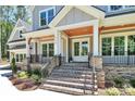 Inviting front porch with stone accents, brick steps, and a stylish wood ceiling at 6178 Chimney Bluff Rd, Lancaster, SC 29720