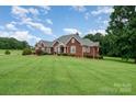 Traditional brick home with a well-manicured lawn and mature shade trees at 720 Miller Chapel Rd, Salisbury, NC 28147