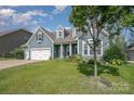 Charming home with a three-car garage, beautiful green lawn, and mature trees at 2009 Atherton Dr, Indian Trail, NC 28079