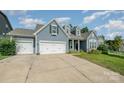 Charming home with a three-car garage, long driveway, and green lawn at 2009 Atherton Dr, Indian Trail, NC 28079