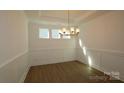 Bright dining room with hardwood floors, chandelier, and wainscoting at 10108 Whitaker Pointe Dr, Huntersville, NC 28078