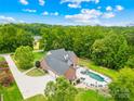 An aerial view showcasing the home's expansive backyard, private pool, and lush green surroundings at 112 Berea Baptist Church Rd, Stanfield, NC 28163