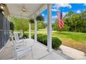 Inviting covered front porch with rocking chairs, ferns, and an American flag at 112 Berea Baptist Church Rd, Stanfield, NC 28163