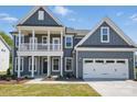 Charming two-story home with gray siding, white trim, a balcony, and a two-car garage at 3253 Mcharney Dr # 27, Harrisburg, NC 28075
